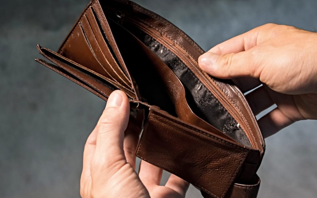 A man looking in an empty brown wallet