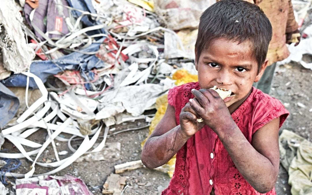 Young impoverished boy eating food