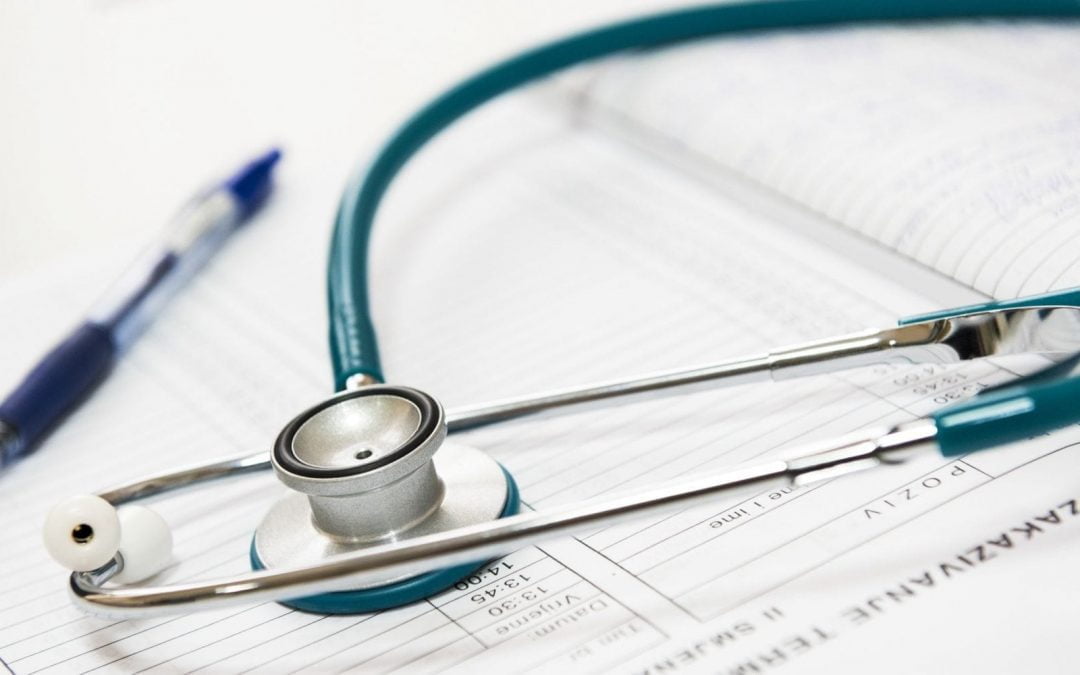 Stethoscope and pen atop medical form