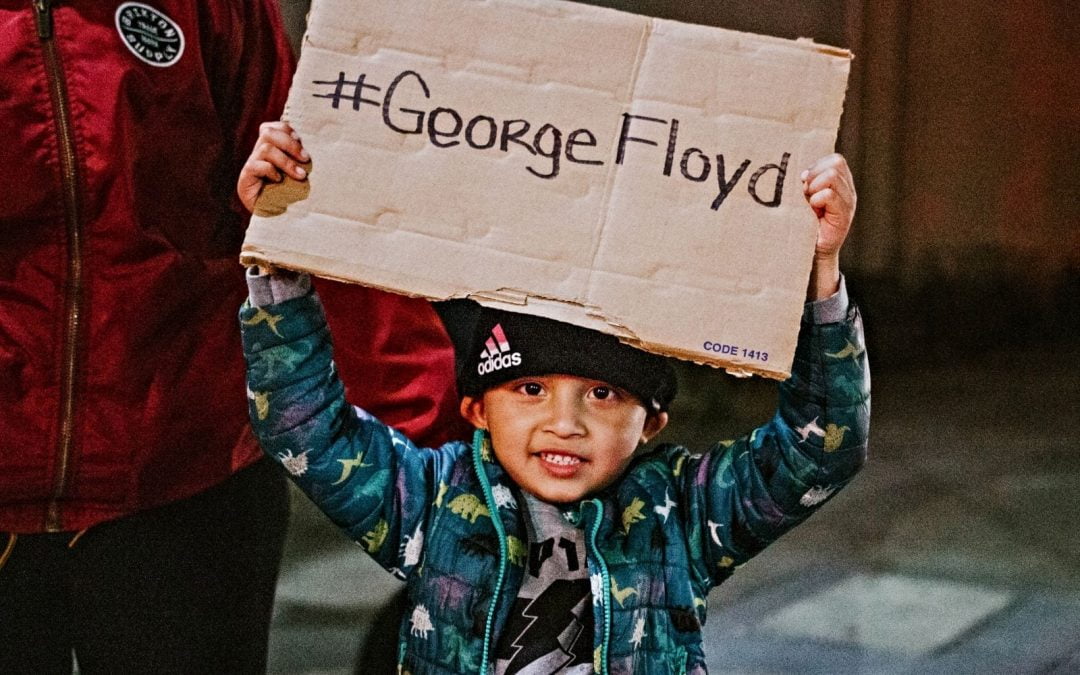 Child holding up sign saying #GeorgeFloyd