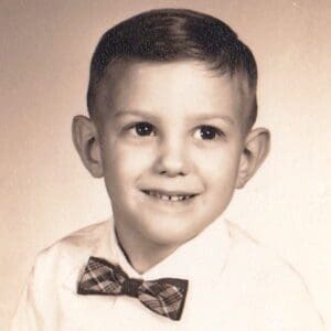A young boy wearing a bowtie and white shirt.