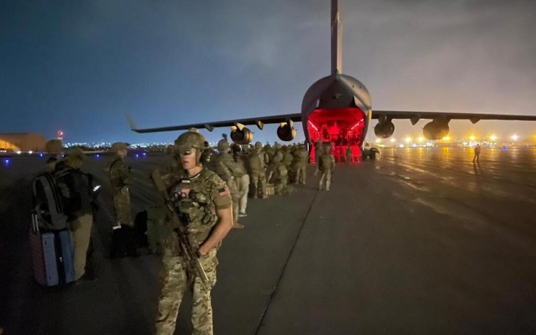 U.S. soldiers board a plane in Afghanistan at night.