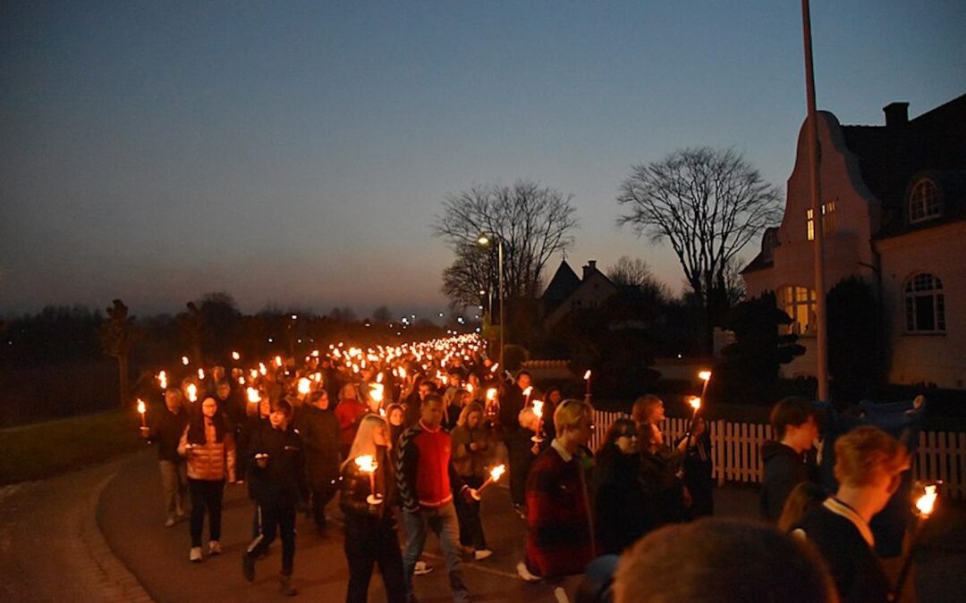 People walking with candles and lights in a peace demonstration for Ukraine.