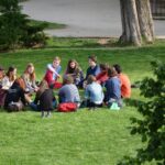 A group of college students sitting outside in a circle.