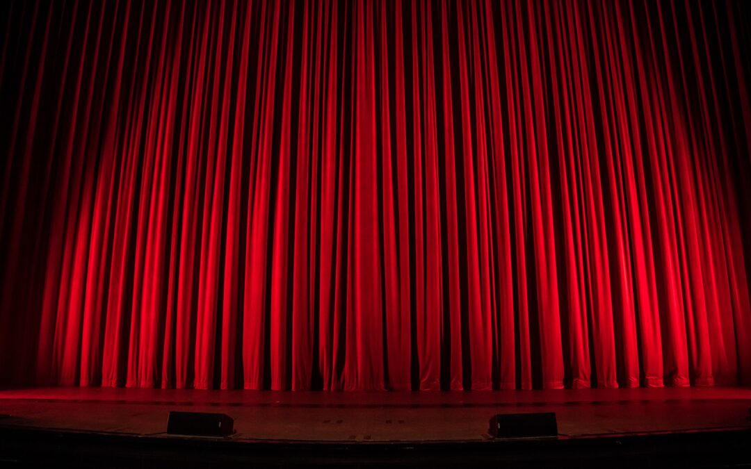 A red curtain on a large theater stage.