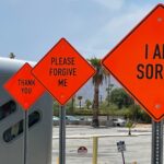 Three road signs the color orange in the shape of diamonds in a row with the words, “I am sorry,” “Please forgive me,” and “Thank you” on them.