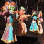 Colorful puppets hanging from strings.