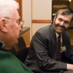 A Jewish rabbi serving as a hospital chaplain visiting with a patient in a hospital.