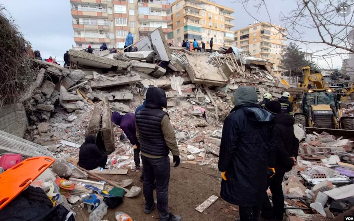 People in Turkey viewing the wreckage of collapsed buildings due to an earthquake.