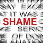 The word “Shame” written in red, surrounded by blurry words in black typeface.
