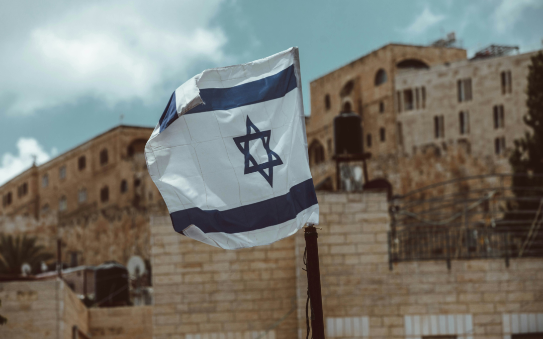 A photo of the Israel flag flying in Jerusalem.