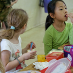A photo of young girls eating in a school cafeteria.