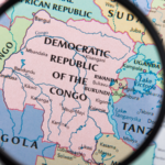 A magnifying glass hovering over a map of the Democratic Republic of Congo.