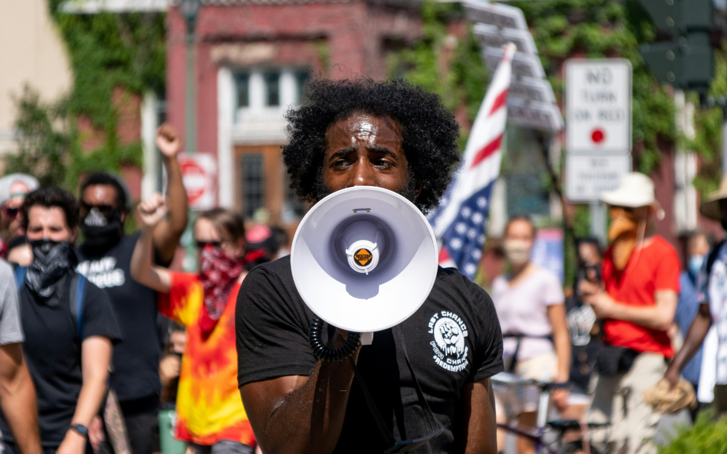 A photo of an organizer speaking into a bullhorn at a protest