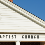 The front of a church with the words “Baptist Church” isolated.