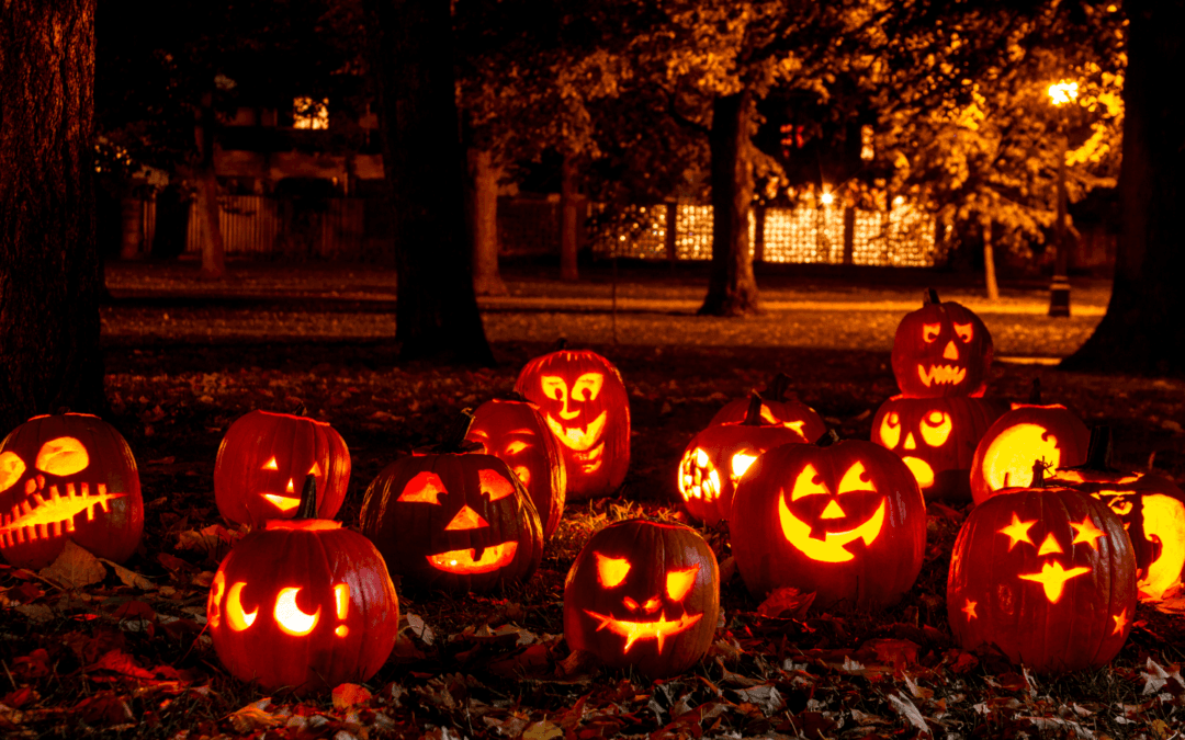 A photo of jack-o-lanterns out in the woods.