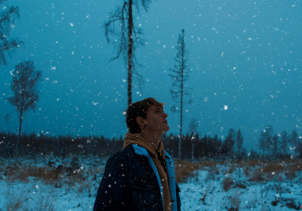 A person walking at dusk in the snow.