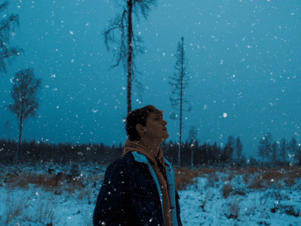 A person walking at dusk in the snow.