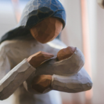 A carved wooden figure of Mary with the baby Jesus.