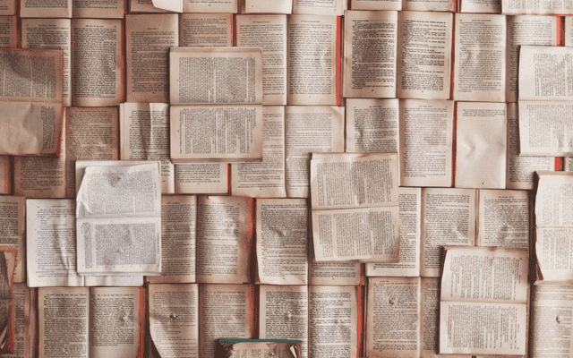 Multiple books layers on top of each other with the pages open.