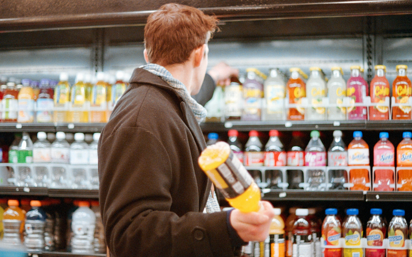A man standing in the soda aisle of a grocery store.