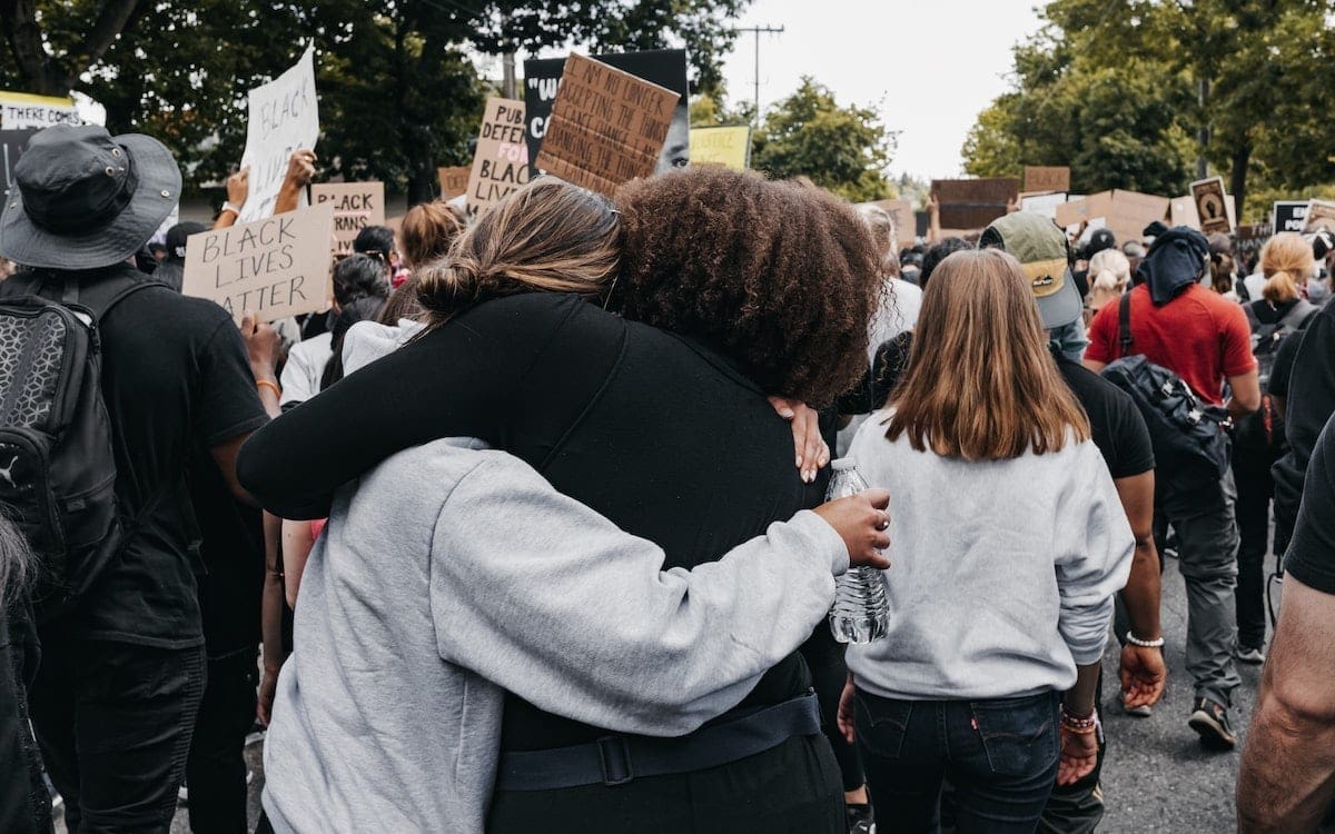 Two women hugging at a Black Lives Matter protest.