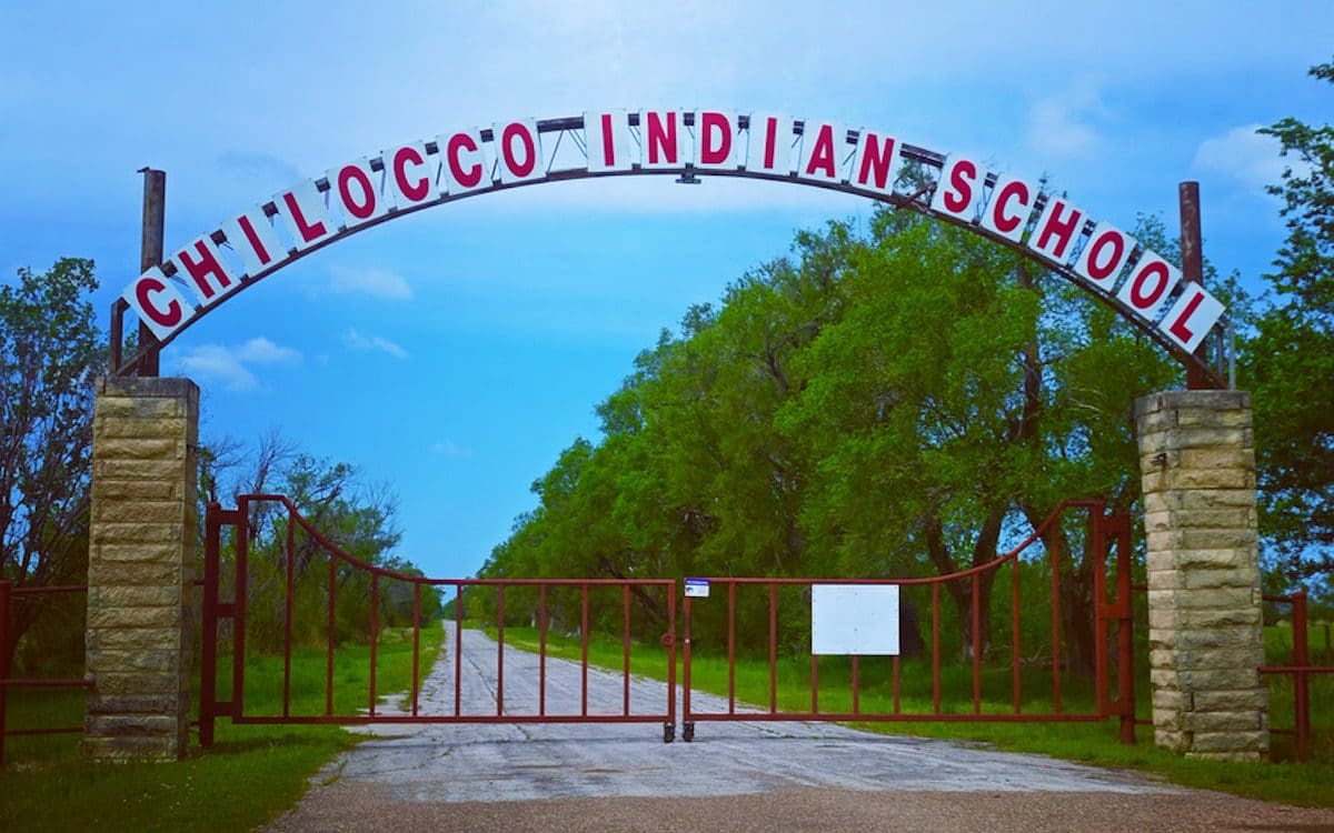 A metal arch over a road with a sign that says