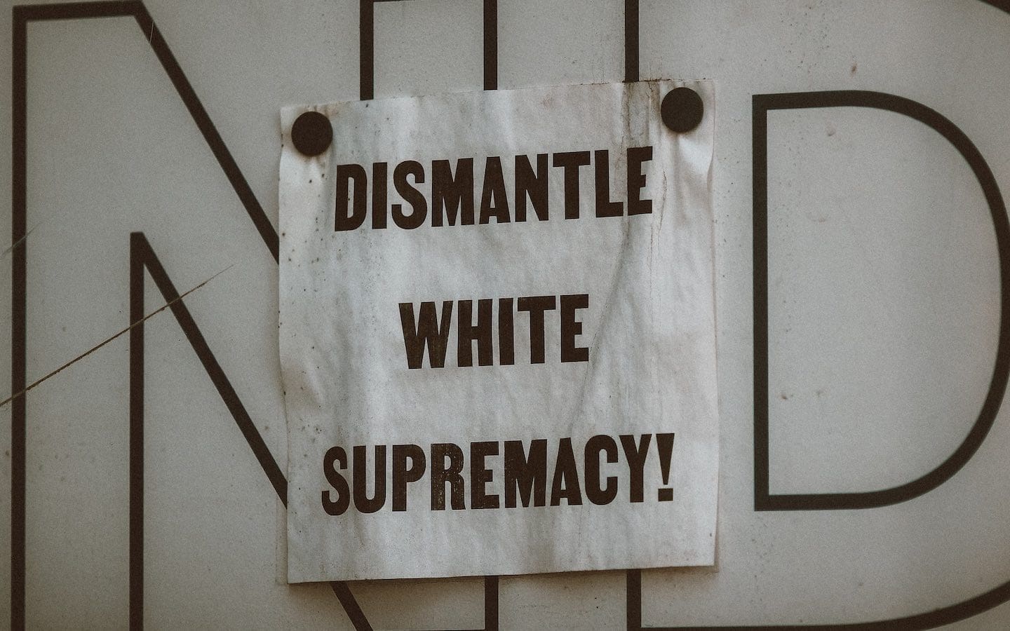A white sign on a wall with bold