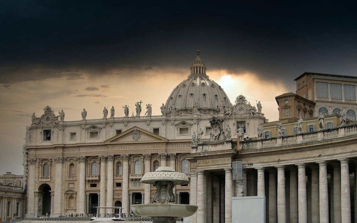 A building in Vatican City with the sun rising behind the clouds
