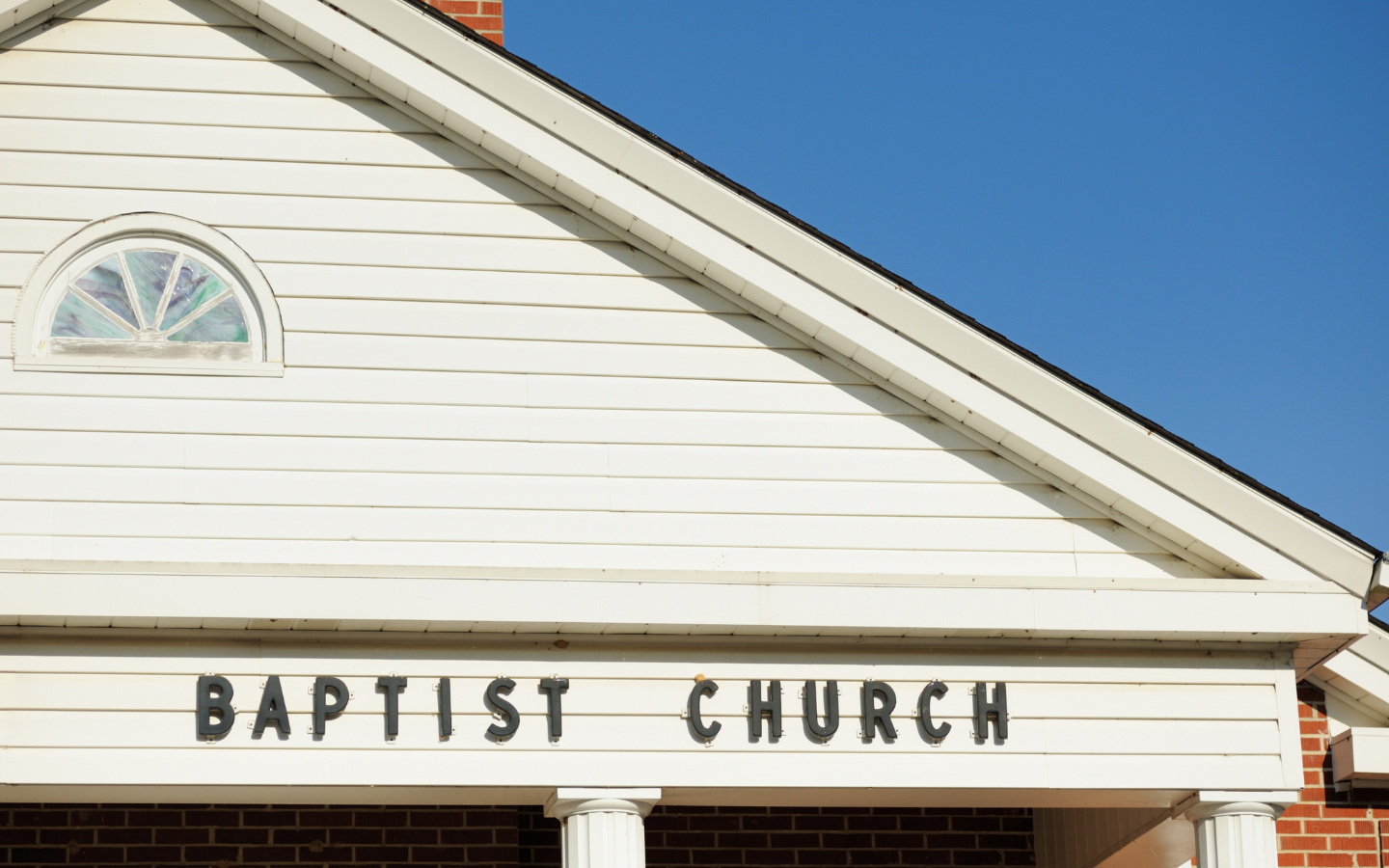 The front of a church with the words “Baptist Church” isolated.