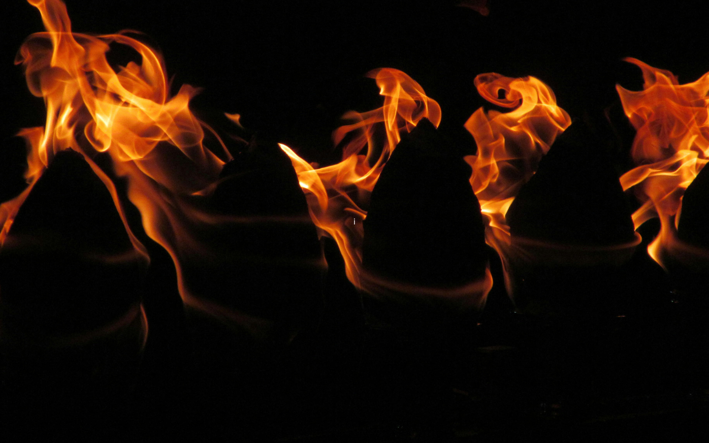Flames coming from oil lamps in the dark.